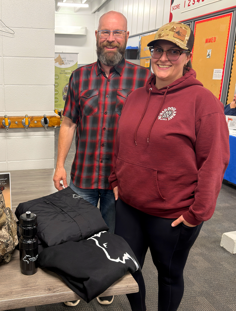 Ken and woman stand next to the the prize package donated by Wolfe Automotive